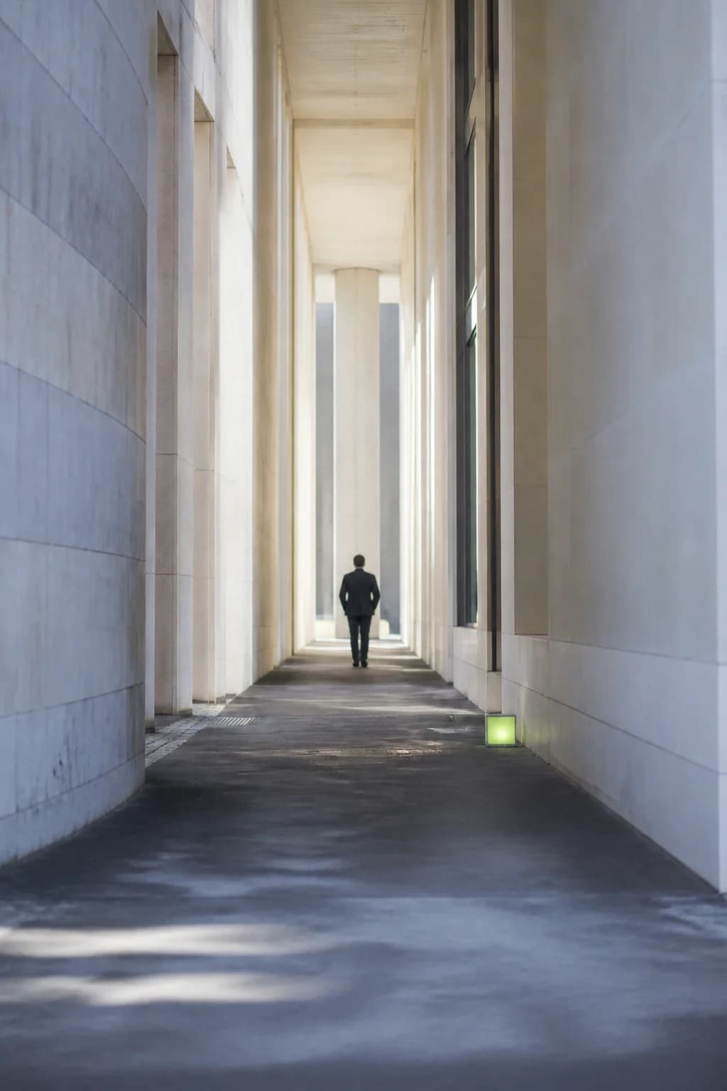 Quiet architectural corridor with a distant figure